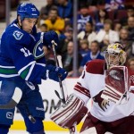 Vancouver Canucks' Dale Weise, left, attempts to tip the puck as Phoenix Coyotes' goalie Mike Smith makes the save during the first period of an NHL hockey game in Vancouver, British Columbia, on Monday April 8, 2013. (AP Photo/The Canadian Press, Darryl Dyck)