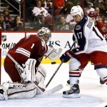 Columbus Blue Jackets' Brandon Dubinsky (17) tries to control the puck to get a shot on goal as Phoenix Coyotes' Jason LaBarbera (1) moves in to make a save during the second period in an NHL hockey game, Wednesday, Jan. 23, 2013, in Glendale, Ariz. (AP Photo/Ross D. Franklin)