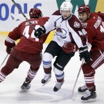 Colorado Avalanche center Mark Oliver, center, leaps between Phoenix Coyotes center Chris Brown, left, and left winger Paul Bissonnette, right, in the third period of NHL hockey game Saturday, April 6, 2013, in Glendale, Ariz. The Coyotes won 4-0. (AP Photo/Paul Connors)
