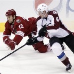 Phoenix Coyotes left winger Paul Bissonnette, left, and Colorado Avalanche defenseman Erik Johnson, right, compete for a loose puck in the third period of an NHL hockey game Saturday, April 6, 2013, in Glendale, Ariz. The Coyotes won 4-0. (AP Photo/Paul Connors)
