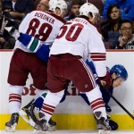 Phoenix Coyotes' Mikkel Boedker, left, of Denmark, and Antoine Vermette, right, check Vancouver Canucks' Mason Raymond during the first period of an NHL hockey game in Vancouver, British Columbia, on Monday April 8, 2013. (AP Photo/The Canadian Press, Darryl Dyck)