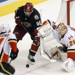 Phoenix Coyotes center Antoine Vermette tries to wrap the puck past Calgary Flames goalie Reto Berra during the second period of an NHL hockey game, Tuesday, Jan. 7, 2014, in Glendale, Ariz. (AP Photo/The Arizona Republic, Michael Chow)