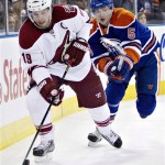 Phoenix Coyotes' Shane Doan (19) controls the puck as he is chased Edmonton Oilers' Ladislav Smid (5) during the first period of an NHL hockey game in Edmonton, Alberta, on Saturday, Feb. 23, 2013. (AP Photo/The Canadian Press, Jason Franson)
