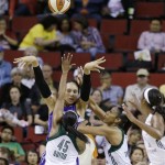 Phoenix Mercury's Brittney Griner, top, gets a pass off while defended by Seattle Storm's Noelle Quinn (45) and Tina Thompson in the first half of a WNBA basketball game on Thursday, Aug. 1, 2013, in Seattle. (AP Photo/Elaine Thompson)