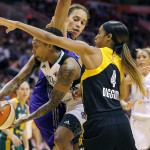 East's Cappie Pondexter, left, passes between West's Brittney Griner, rear, of the Phoenix Mercury and Skylar Diggins, of the Tulsa Shock during the second half the WNBA All-Star basketball game, Saturday, July 19, 2014, in Phoenix. The East won 125-124 in overtime. (AP Photo/Matt York)