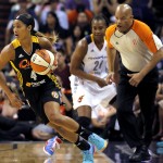 West's Skylar Diggins (4), of the Tulsa Shock, pushes the ball up court as East's Tamika Catchings (24), of the Indiana Fever, looks on during the first half the WNBA All-Star basketball game, Saturday, July 19, 2014, in Phoenix. (AP Photo/Matt York)
