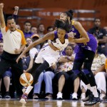 Phoenix Mercury's DeWanna Bonner is fouled by Los Angeles Sparks' Candace Parker, right, as official Thomas Nunez, left, makes the call during the second half in Game 1 of the WNBA basketball Western Conference semifinals Friday, Aug. 22, 2014, in Phoenix. The Mercury defeated the Sparks 75-72. (AP Photo/Ross D. Franklin)