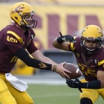Arizona State's Taylor Kelly, left, hands the ball off to teammate R.J. Robinson (35) as they warm up before an NCAA college football game against Sacramento State on Thursday, Sept. 5, 2013, in Tempe, Ariz. (AP Photo/Ross D. Franklin)