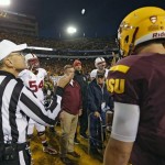 Referee Jay Stricherz flips the coin prior to the start of the NCAA Pac-12 Championship football game as Arizona State quarterback Taylor Kelly (10), and Stanford guard David Yankey (54) look on Saturday, Dec. 7, 2013, in Tempe, Ariz. (AP Photo/Matt York)
