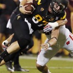Arizona State's Chris Coyle, left, breaks a tackle against Wisconsin's Ethan Armstrong in the first half of an NCAA college football game on Saturday, Sept. 14, 2013, in Phoenix. (AP Photo/Ross D. Franklin)