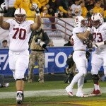 Stanford's Andrus Peat (70) and Cameron Fleming (73) celebrate a touchdown run against Arizona State by teammate Tyler Gaffney, second from right, during the first half of the NCAA Pac-12 Championship football game Saturday, Dec. 7, 2013, in Tempe, Ariz. (AP Photo/Ross D. Franklin)
