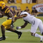 Arizona State running back D.J. Foster, left, tries to break an arm tackle by Weber State cornerback Deon'tae Florence during the first half of an NCAA college football game, Thursday, Aug. 28, 2014, in Tempe, Ariz. (AP Photo/Matt York)