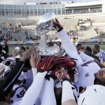 Arizona State players reach out to touch the trophy following their 36-31 victory over Duke in the Sun Bowl NCAA college football game, Saturday, Dec. 27, 2014, in El Paso, Texas. (AP Photo/Victor Calzada)