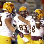 Arizona State's D.J. Foster (8) celebrates his touchdown run against New Mexico with teammates Vi Teofilo (73) and Kody Kohl (83) during the second half of an NCAA college football game Saturday, Sept. 6, 2014, in Albuquerque, N.M. Arizona State defeated New Mexico 58-23. (AP Photo/Ross D. Franklin)