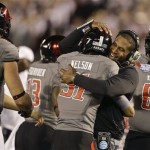 Texas Tech defensive back Justis Nelson is hugged by a coach after his late fourth quarter end zone interception in Texas Tech's 37-23 victory over Arizona State in the Holiday Bowl NCAA college football game Monday, Dec. 30, 2013, in San Diego. (AP Photo/Lenny Ignelzi)