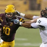 Arizona State's Taylor Kelly (10) runs with the ball as he tangles with Sacramento State's Markell Williams (31) during the first half in an NCAA college football game on Thursday, Sept. 5, 2013, in Tempe, Ariz. (AP Photo/Ross D. Franklin)