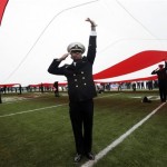 A United States Naval Academy cadet salutes while holding the U.S. flag before the Fight Hunger Bowl NCAA college football game between Navy and Arizona State in San Francisco, Saturday, Dec. 29, 2012. (AP Photo/Marcio Jose Sanchez)
