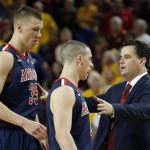 Arizona head coach Sean Miller, right, talks with his players Kaleb Tarczewski (35), and T.J. McConnell during the first overtime of an NCAA college basketball game against Arizona State, Friday, Feb. 14, 2014, in Tempe, Ariz. Arizona State defeated Arizona 69-66 in double overtime. (AP Photo/Ross D. Franklin)