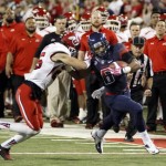 Arizona's Nate Phillips (6) tries to stiff arm Utah's Mike Honeycutt (25)in the first half of an NCAA college football game, Saturday, Oct. 19, 2013 in Tucson, Ariz. (AP Photo/Wily Low)