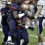 Arizona's Jonathan McKnight (on back) congratulates Devin Holiday (13) for intercepting a pass against Northern Arizona during the second half of an NCAA college football game at Arizona Stadium in Tucson, Ariz., Friday, Aug. 30, 2013. (AP Photo/John Miller)