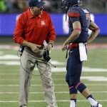 Arizona's head coach Rich Rodrigues, left, speaks with his quarterback B.J. Denker (7) in the first half of an NCAA collge football game, Saturday, Oct. 19, 2013 in Tucson, Ariz. (AP Photo/John Miller) 