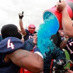 Arizona head football coach Rich Rodriguez is doused by his players after their 49-48 win over New Mexico in the New Mexico Bowl NCAA college football game in Albuquerque, N.M., Saturday, Dec. 15, 2012. (AP Photo/Eric Draper)