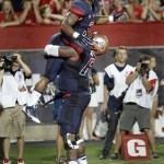 Arizona's Daniel Jenkins (3) is lifted into the air by teammate Cayman Bundage (61) after scoring a touchdown against Northern Arizona during the first half of an NCAA college football game at Arizona Stadium in Tucson, Ariz., Friday, Aug. 30, 2013. (AP Photo/Wily Low)
