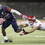 Arizona's Ka'Deem Carey (25) tries to out run the reach of Utah's Jared Norris (41) in the first half of an NCAA college football game, Saturday, Oct. 19, 2013 in Tucson, Ariz. (AP Photo/Wily Low)