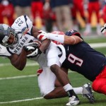 Nevada running back Stefphon Jefferson struggles for yardage against Arizona's C.J. Dozier (9) during the first half of the New Mexico Bowl NCAA college football game in Albuquerque, N.M., Saturday, Dec. 15, 2012. Arizona won 49-48. (AP Photo/Eric Draper)
