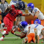 Arizona tight end Alexei Oro (42) is hit by Boise State linebacker Ben Weaver (51) and Boise State linebacker Tanner Vallejo (20) during the first half of the Fiesta Bowl NCAA college football game, Wednesday, Dec. 31, 2014, in Glendale, Ariz. (AP Photo/Rick Scuteri)