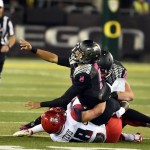 Oregon quarterback Marcus Mariota (8) pitches the ball as he is tackled by Arizona safety Jared Tevis (38) during the first quarter of an NCAA college football game Thursday, Oct. 2, 2014, in Eugene, Ore. (AP Photo/Steve Dykes)
