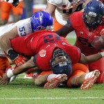 Arizona quarterback Anu Solomon (12) falls backwards after being hit by Boise State defensive end Beau Martin (53) during the first half of the Fiesta Bowl NCAA college football game, Wednesday, Dec. 31, 2014, in Glendale, Ariz. (AP Photo/Ross D. Franklin)