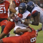 Utah defensive tackle Sese Ianu (57) and Nate Orchard (8) tackle Arizona running back Terris Jones-Grigsby (24) in the first half during an NCAA college football game, Saturday, Nov. 22, 2014, in Salt Lake City. (AP Photo/Rick Bowmer)