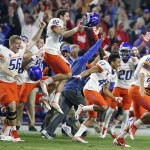 Boise State players and coaches run on the field as they celebrate their win as time expires in the second half of the Fiesta Bowl NCAA college football game against Arizona Wednesday, Dec. 31, 2014, in Glendale, Ariz. Boise State won 38-30. (AP Photo/Ross D. Franklin)