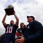 Arizona's Matt Scott holds the game trophy while celebrating with teammate Marquis Flowers (2) and head coach Rich Rodriguez after beating Nevada 49-48 in the New Mexico Bowl NCAA college football game in Albuquerque, N.M., Saturday, Dec. 15, 2012. (AP Photo/Eric Draper)
