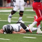Nevada quarterback Cody Fajardo lays face down after getting hit by Arizona's defense in the second against of the New Mexico Bowl NCAA college football game in Albuquerque, N.M., Saturday, Dec. 15, 2012. Fajardo left the game after the play but returned later. Arizona won 49-48. (AP Photo/Eric Draper)

