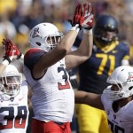 Arizona linebacker Scooby Wright, center, celebrates with safety Jared Tevis (38) and defensive lineman Kirifi Taula after California running back running back Darren Ervin was tackled for a safety during the first quarter of an NCAA college football game in Berkeley, Calif., Saturday, Nov. 2, 2013. (AP Photo/Jeff Chiu)