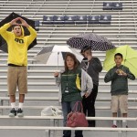  Oregon fans that are from New Mexico wait in the rain in an empty stadium for the game to start against Arizona in an NCAA college football game on Saturday, Nov. 23, 2013 in Tucson, Ariz. (AP Photo/John MIller)