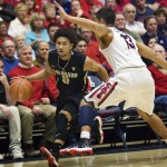 Colorado's Askia Booker (0) drives to the basket around Arizona's Nick Johnson (13) during the first half of an NCAA college basketball game at McKale Center in Tucson, Ariz., Thursday, Jan. 3, 2013. (AP Photo/Wily Low)