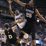 Arizona's Mark Lyons shoots between Harvard's Kenyatta Smith, right, and Laurent Rivard, left, in the second half during a third-round game in the NCAA men's college basketball tournament in Salt Lake City on Saturday, March 23, 2013. Arizona defeated Harvard 74-51. (AP Photo/George Frey)
