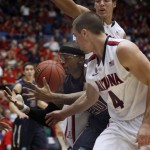 Fairleigh Dickinson's Xavier Harris (20) battles for a loose ball against Arizona's T.J. McConnell (4) and Aaron Gordon, behind, in the first half of an NCAA college basketball game, Monday, Nov. 18, 2013 in Tucson, Ariz. (AP Photo/Wily Low)