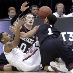 Arizona's Mark Lyons, lower left, reaches for a loose ball with Harvard's Laurent Rivard (0) and Siyani Chambers (1) in the first half during a third-round game in the NCAA men's college basketball tournament in Salt Lake City on Saturday, March 23, 2013. (AP Photo/Rick Bowmer)
