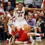 Arizona guard T.J. McConnell (4) reaches for the ball as he falls down next to Stanford guard Chasson Randle (5) and forward Josh Huestis (24) during the second half of an NCAA college basketball game on Wednesday, Jan. 29, 2014, in Stanford, Calif. Arizona won 60-57. (AP Photo/Marcio Jose Sanchez)