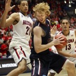 Fairleigh Dickinson's Mathias Seilund (22) looks for an opening between Arizona's Brandon Ashley (21) and Nick Johnson (13) in the first half of an NCAA college basketball game, Monday, Nov. 18, 2013 in Tucson, Ariz. (AP Photo/Wily Low)