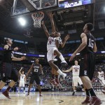 Arizona's Mark Lyons, center puts a shot over Harvard's Wesley Saunders, back, as Laurent Rivard, left, and Christian Webster look on in the second half during a third-round game in the men's NCAA college basketball tournament in Salt Lake City on Saturday, March 23, 2013. Arizona beat Harvard 74-51. (AP Photo/George Frey)
