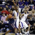 Arizona's Kevin Parrom, left, passes around the defense of Washington's Shawn Kemp Jr., second from left, as teammate Scott Suggs (15) looks on in the first half of an NCAA college basketball game, Thursday, Jan. 31, 2013, in Seattle. (AP Photo/Ted S. Warren)