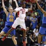 Arizona's Rondae Hollis-Jefferson, center, passes against UCLA's Thomas Welsh, left, and UCLA's Norman Powell, right, during the first half of an NCAA college basketball game in the semifinals of the Pac-12 conference tournament Friday, March 13, 2015, in Las Vegas. (AP Photo/John Locher)