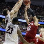 Wisconsin 's Traevon Jackson (12) tries to shoot with Arizona's Rondae Hollis-Jefferson (23) and Aaron Gordon (11) defending during the second half in a regional final NCAA college basketball tournament game, Saturday, March 29, 2014, in Anaheim, Calif. (AP Photo/Alex Gallardo)
