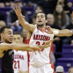 Washington's Nigel Williams-Goss, left, passes as Arizona's Elliott Pitts defends during the first half of an NCAA college basketball game Friday, Feb. 13, 2015, in Seattle. (AP Photo/Elaine Thompson)