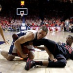 Arizona guard T.J. McConnell, center, and Utah guard Delon Wright (55) battle for the ball during the first half of an NCAA college basketball game, Saturday, Jan. 17, 2015, in Tucson, Ariz. (AP Photo/Rick Scuteri)

